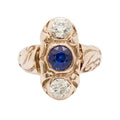 Gold ring with a blue gemstone and two diamonds on a white background
