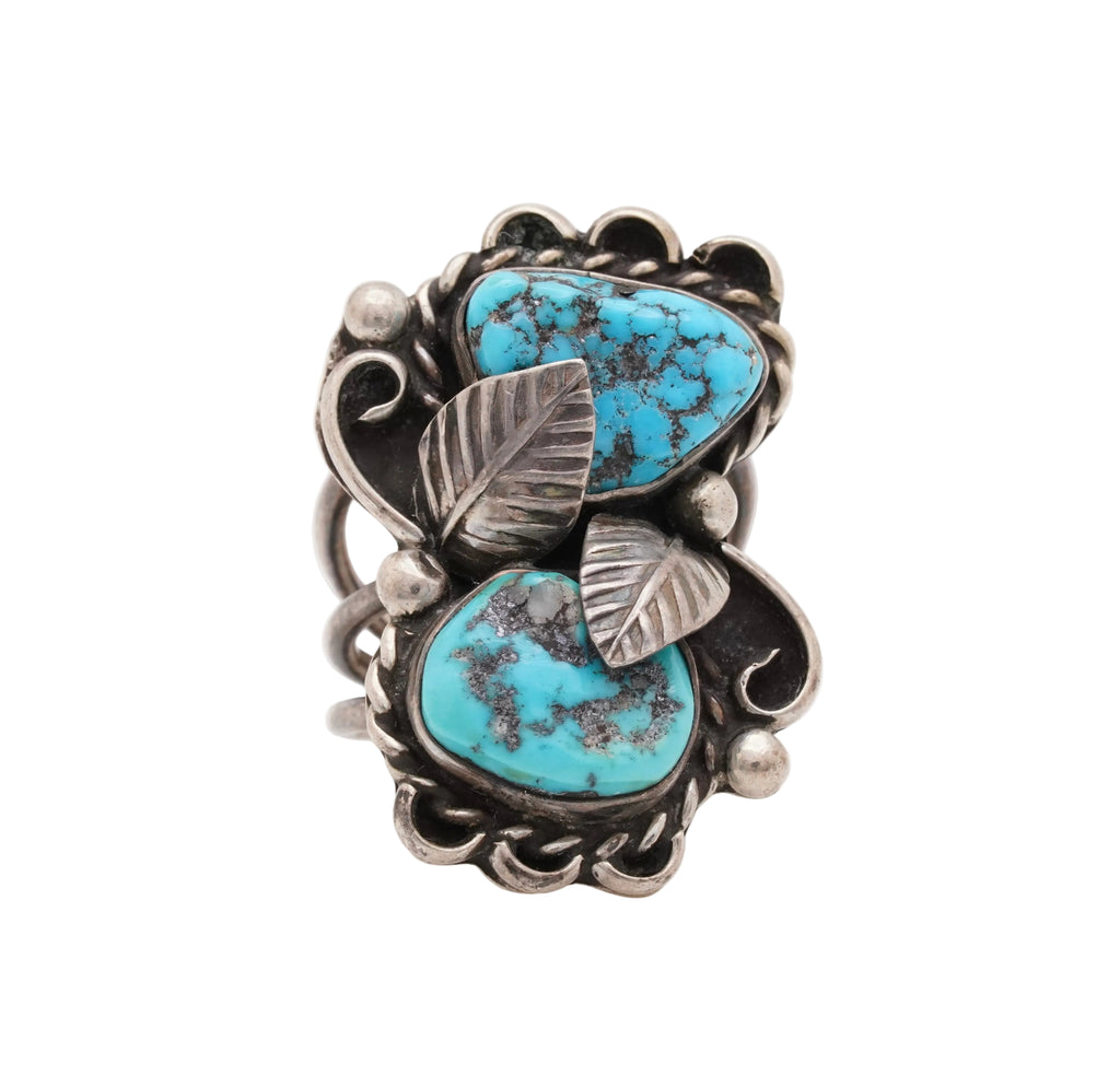 Silver ring with turquoise stones and leaf designs on a white background