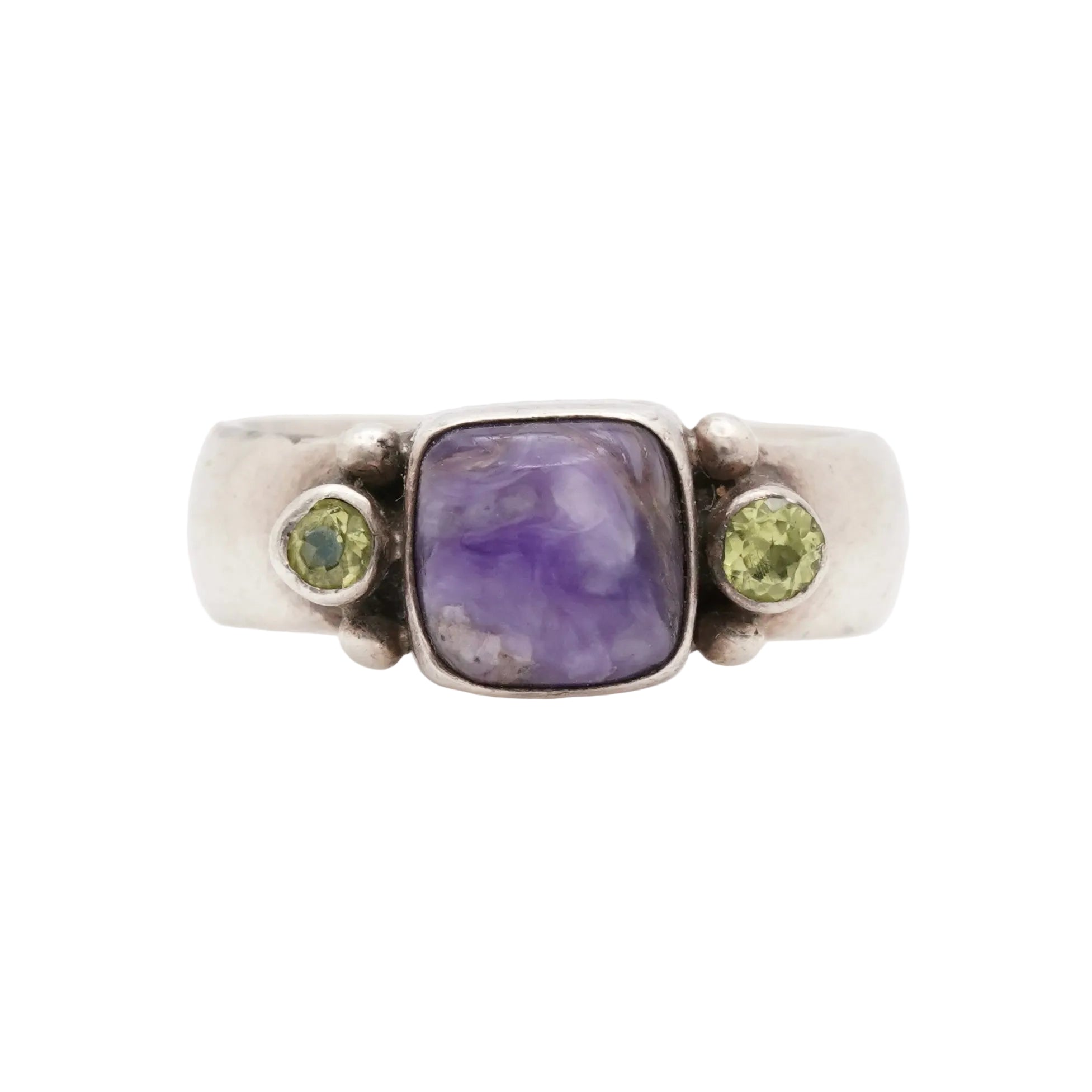 Silver ring with a charoite gemstone and two green gemstones on a white background