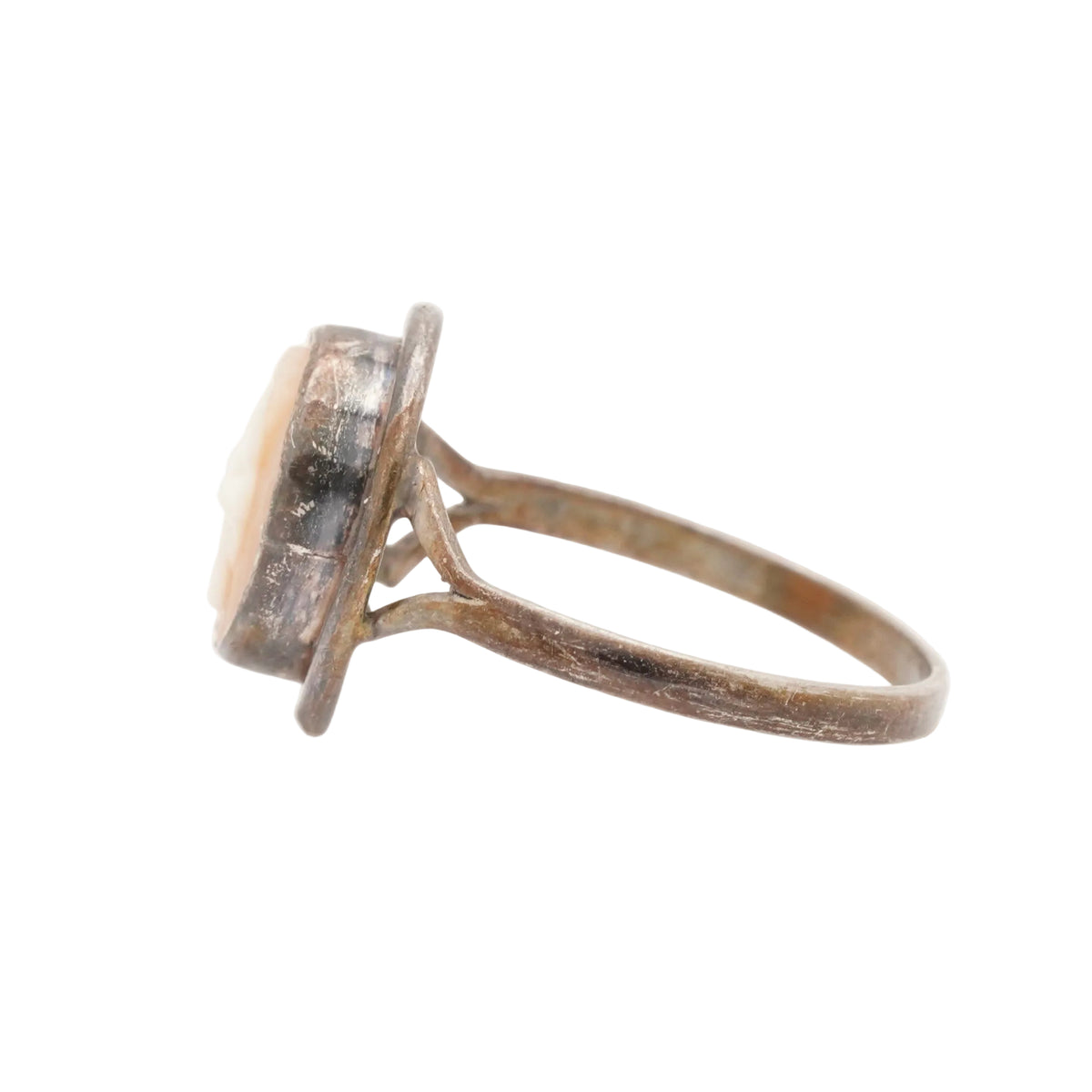 A vintage-style ring with a distressed, rusted brown metal band and a round cabochon gemstone showing a pale pinkish-beige hue, set against a plain white background.