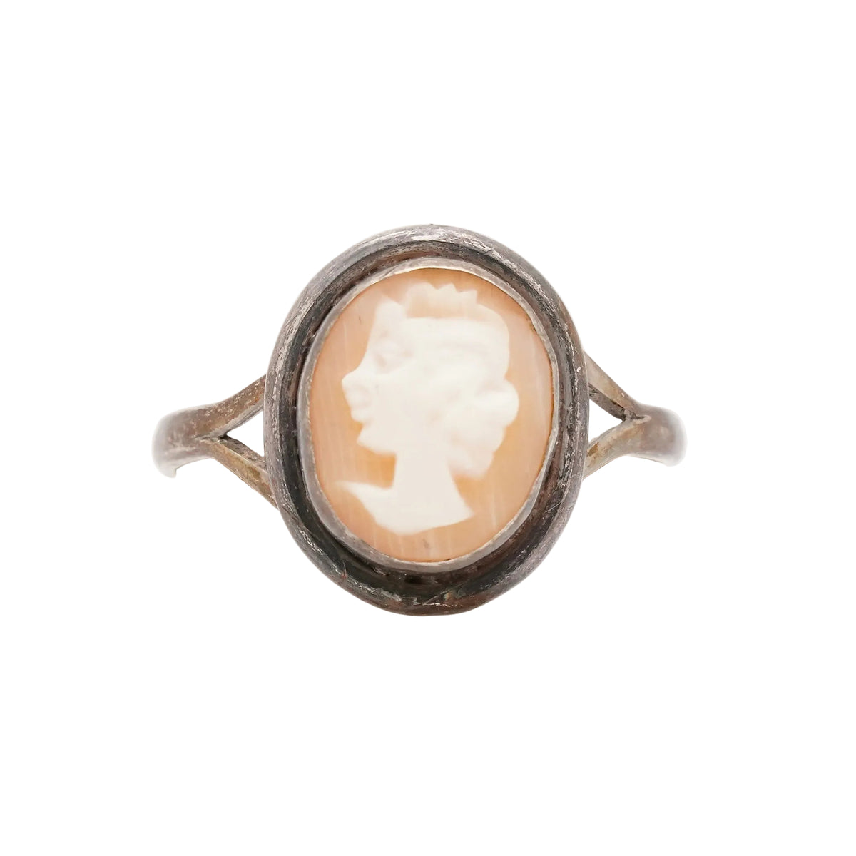 A vintage-style ring featuring an oval carved cameo cabochon with a profile portrait in warm peach and cream tones, set in a dark oxidized silver-toned metal band.