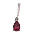 Sterling silver pendant with a pear-shaped synthetic ruby in a three-prong setting and a small round diamond at the bail, on a light grey background.