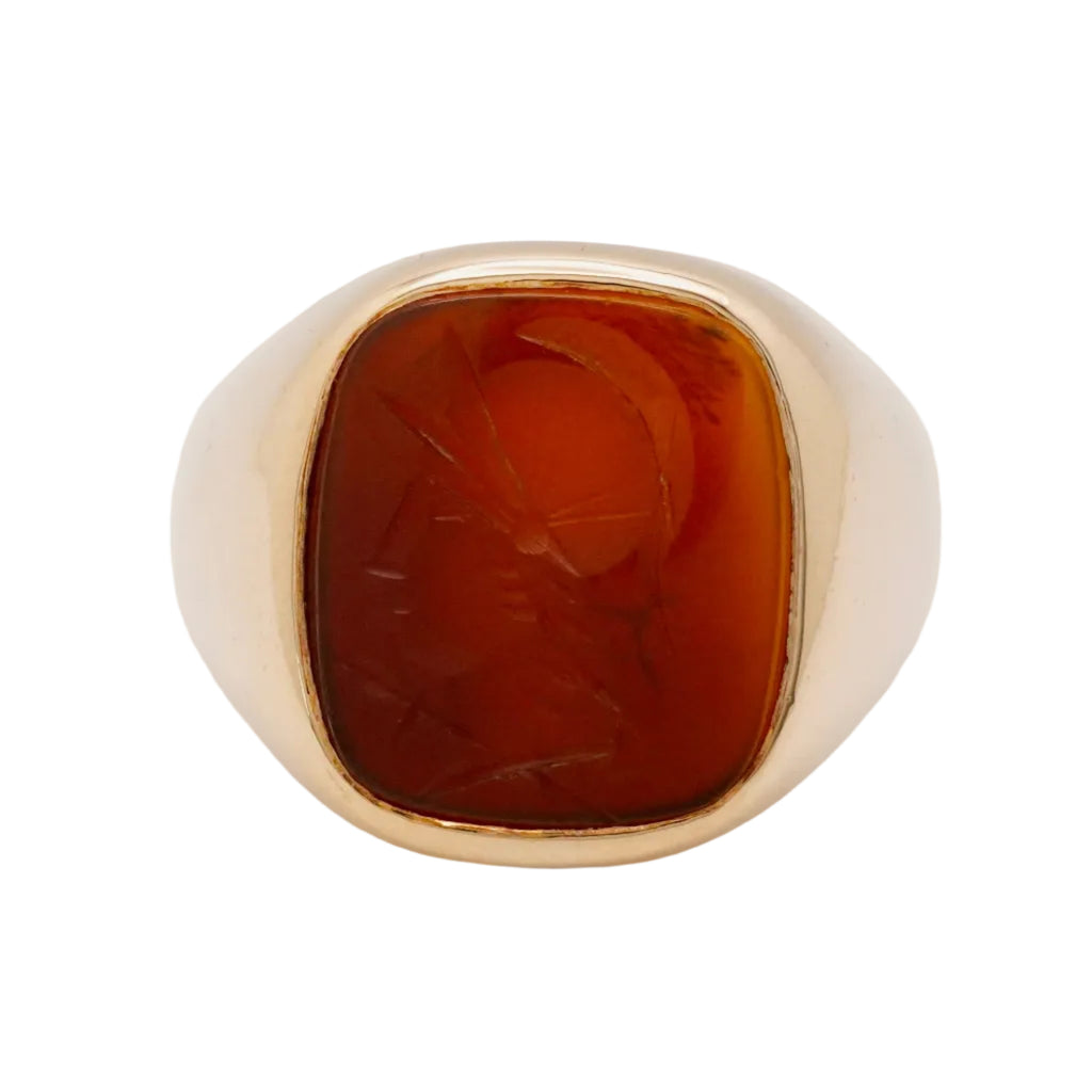 Gold ring with a brown stone on a light gray background