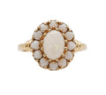 Gold ring with a central opal stone on a white background