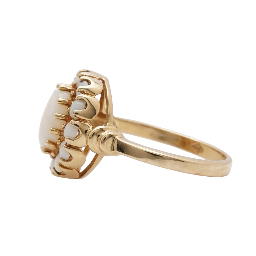 Gold ring with a central stone on a light gray background