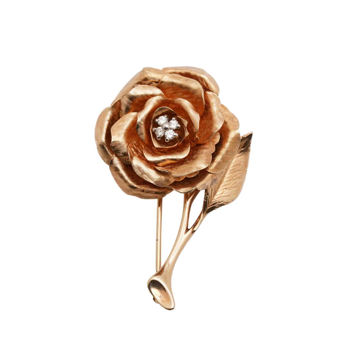 A vintage gold rose brooch with a small cluster of clear stones in the center, set against a plain light gray background.